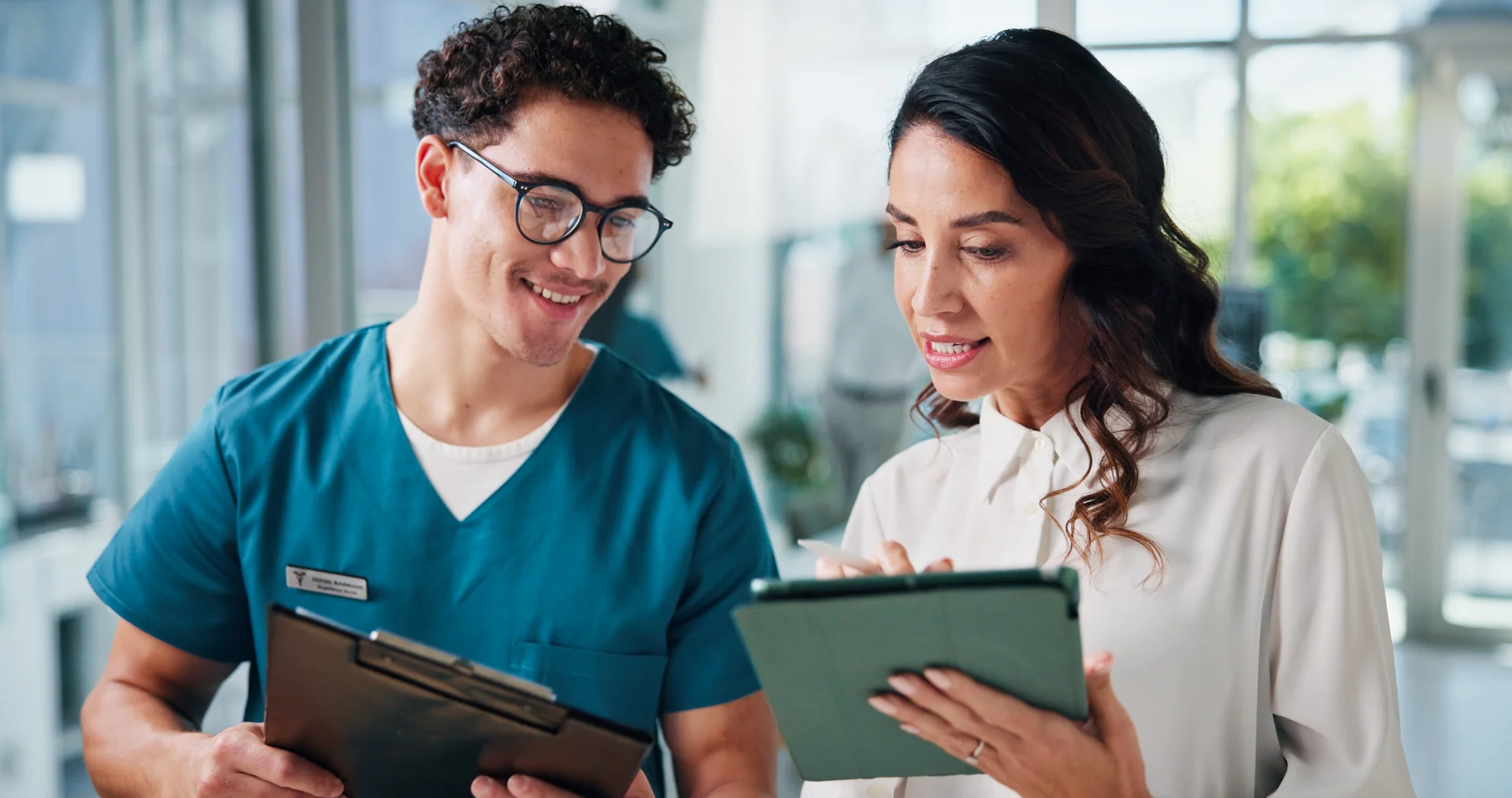 Two healthcare colleagues reviewing information together on a tablet