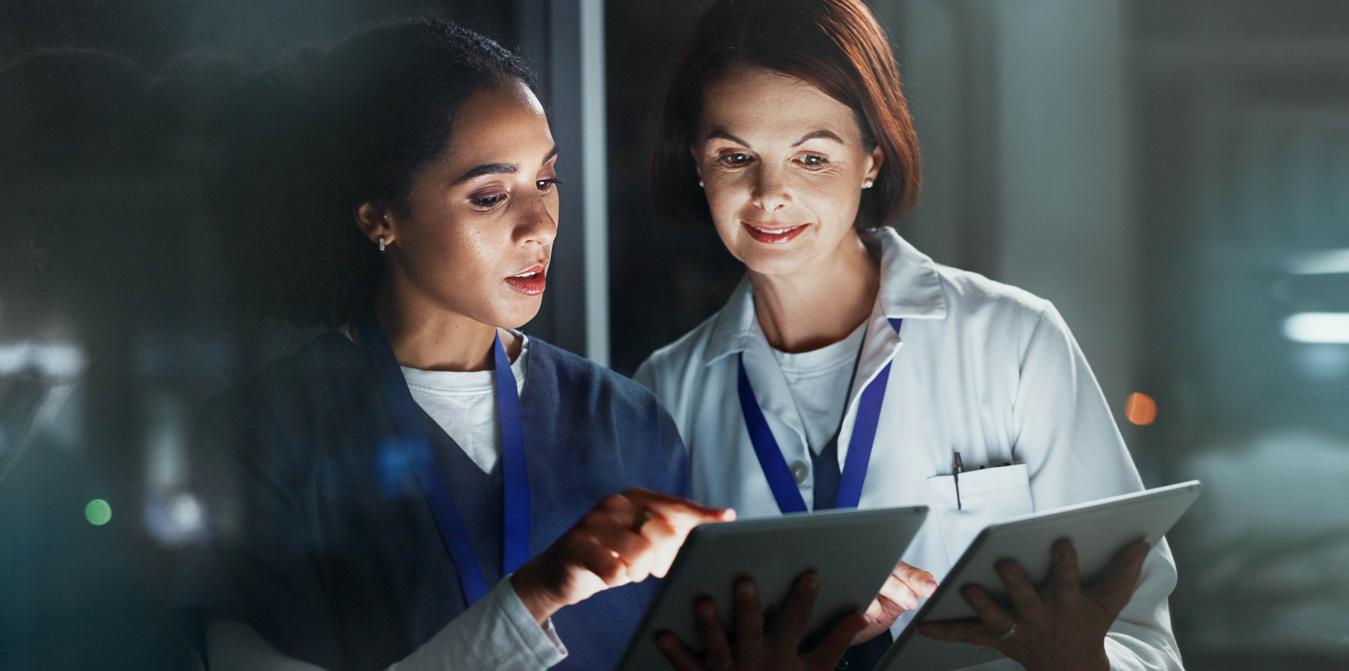 Two clinicians reviewing information together on tablets, representing coached evidence-based practice support for clinical nurses.